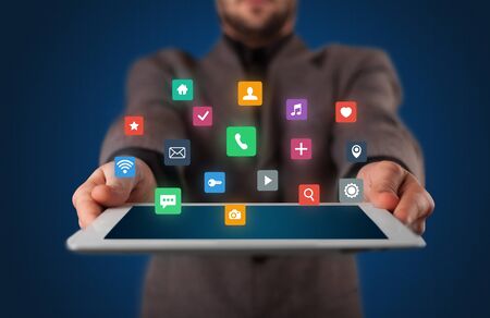 Businessman holding tablet with colorful applications