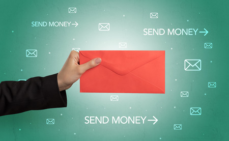 Female hand holding empty and full envelope with green background and symbols aroundの写真素材