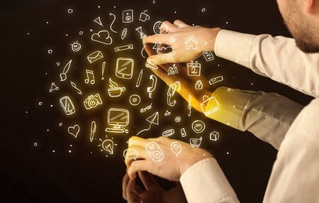 Male hands touching interactive table with yellow mixed media icons on itの写真素材