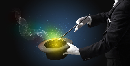 Illusionist hand starts to conjure with white glove and magic wandの写真素材