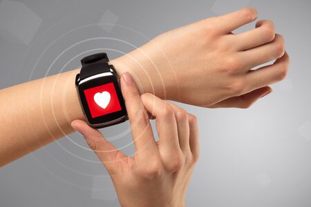 Naked female hand with smartwatch and with heart rate icon on the watchの写真素材