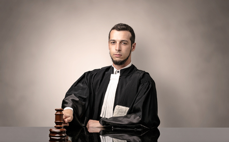 Young dashing judge in black gown making decision with no conceptの写真素材