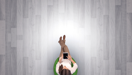 Empty office with woman in a chair and device on her hand
の写真素材