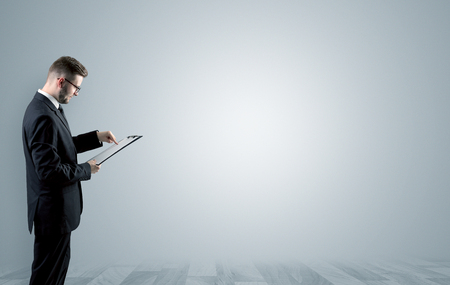 Elegant businessman standing and presenting something in an empty space with floor
の写真素材