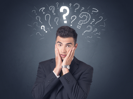 Young businessman with white question marks above his headの写真素材