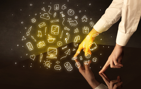 Male hands touching interactive table with yellow mixed media icons on itの写真素材