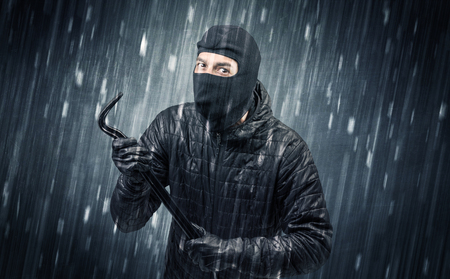 Burglar in action in black clothes with rainy concept. の写真素材