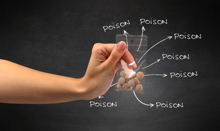 Hand with pills in plastic bag and blackboard wallpaper