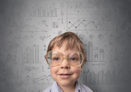 Little boy in front of a grey wall with graphs and statistics aroundの写真素材