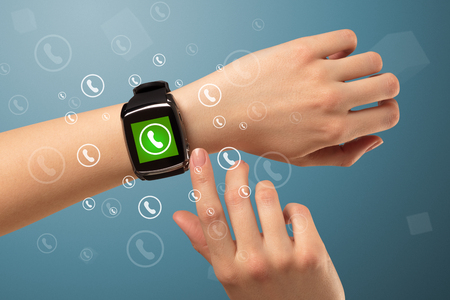 Female handwearing a ringing smartwatch with call icons aroundの写真素材