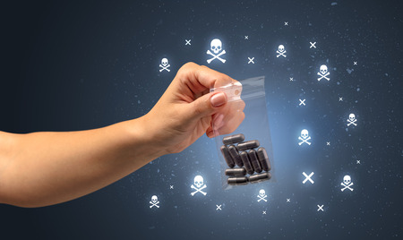 Female handing over pills with skull concept の写真素材