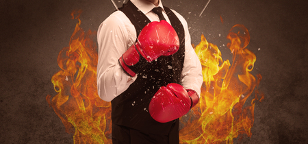 A strong sales person breaking something into pieces with red boxing gloves concept illustrated with glowing residue flying in the air.の写真素材