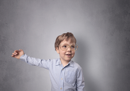 Adorable little boy portrait with empty grey wall backgroundの写真素材