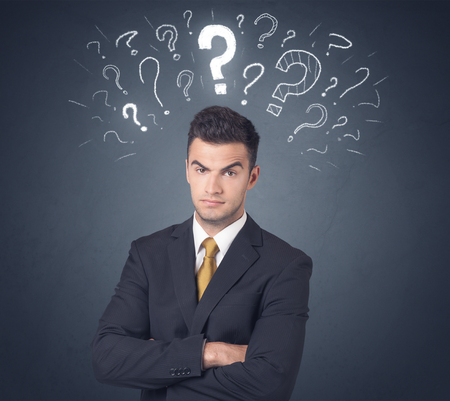 Young businessman with white question marks above his headの写真素材