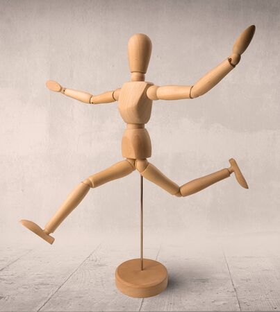 Wooden mannequin posed in front of a greyish backgroundの写真素材