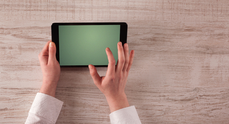 Caucasian business hands holding and working on plain tabletの写真素材