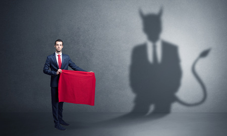 Businessman with devil shadow and toreador conceptの写真素材