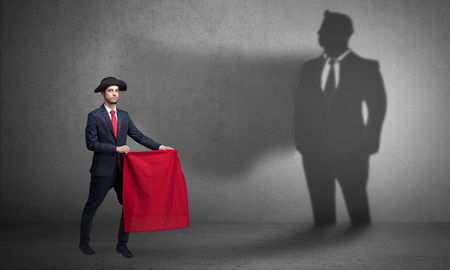 Businessman with toreador concept and his shadow on the backgrouの写真素材