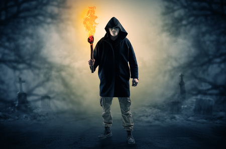 Man coming out from a thicket with burning flambeauの写真素材