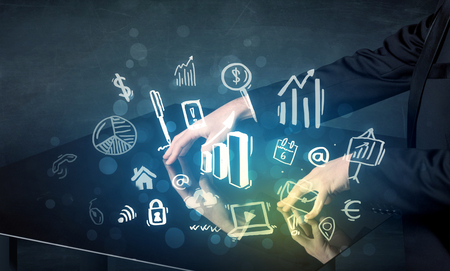 Man touching technology smart table with business icons and symbolsの写真素材