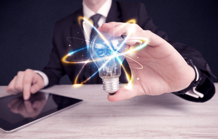 businessman holding a colorful light bulbの写真素材