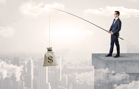 Businessman fishing currency from the city conceptの写真素材
