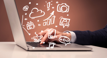 An elegant businessman sitting at desk and pushing the buttons of his laptop keyboard while working on everyday office tasksillustration conceptの写真素材