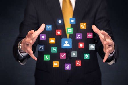 Colorful multimedia icons in the hands of a businessmanの写真素材
