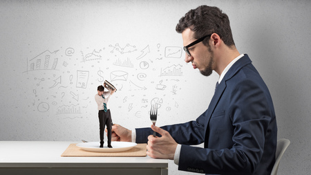 Big businessman eating small employee with doodled charts conceptの写真素材