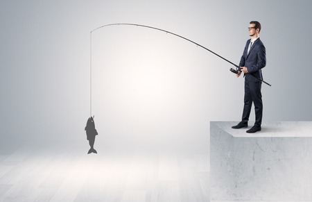 Businessman fishing golden fish conceptの写真素材