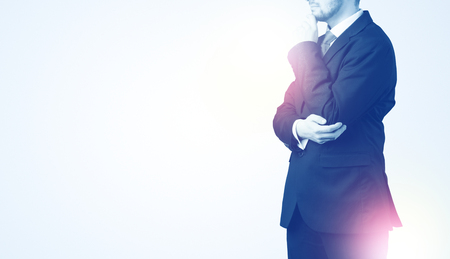 Young businessman standing and thinkingの写真素材
