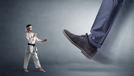 Big foot treading small karate manの写真素材