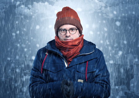 Boy freezing in cold weather with city conceptの写真素材