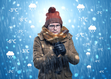 Boy freezing in warm clothing with weather condition conceptの写真素材
