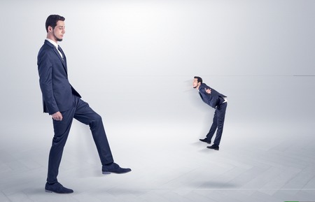Small man fired by boss with white wallpaperの写真素材