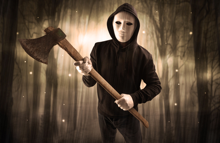 Armed hitman in dark nocturnal forest conceptの写真素材