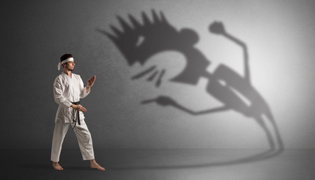 Karate man fighting with a big scary shadowの写真素材