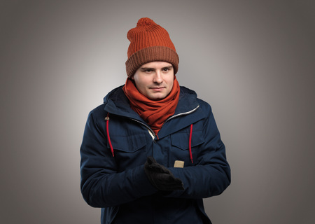 Handsome boy freezing in warm clothing