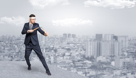 Suited karate man doing karate tricks on the top of a metropolitan cityの写真素材