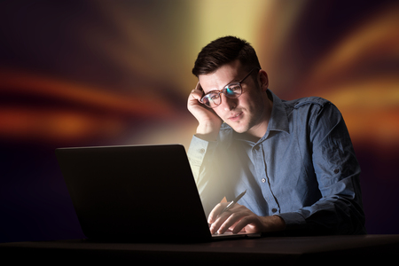 Businessman in the office at nightの写真素材