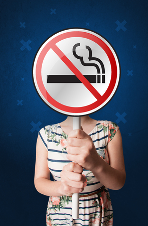 Casual young woman holding round sign with no smoking graphicの写真素材
