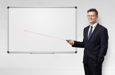 Businessman with laser pointer and copyspace white blackboardの写真素材