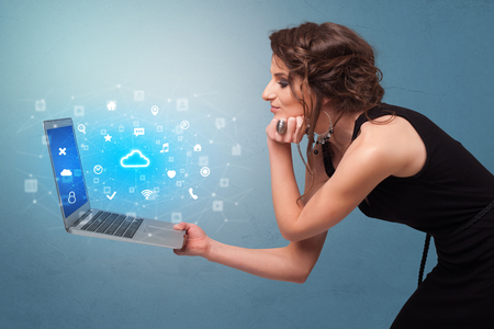 Woman holding laptop with cloud based system notificationsの写真素材