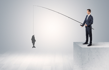 Businessman fishing golden fish conceptの写真素材