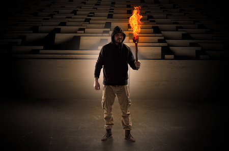 Man coming with burning flambeau from the maze conceptの写真素材