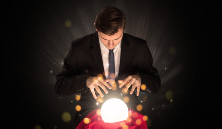 Businessman  sitting with sparkling magic ballの写真素材