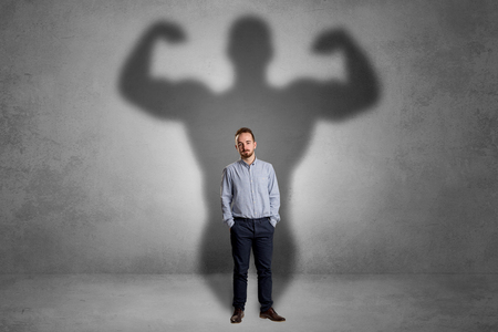 Businessman with muscular shade behind his backの写真素材