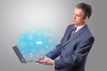 Man holding laptop with cloud based system concept