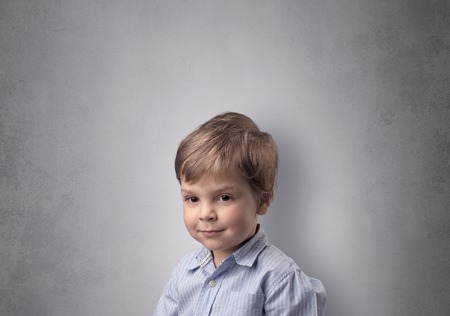 Adorable little boy in front of an empty wallの写真素材