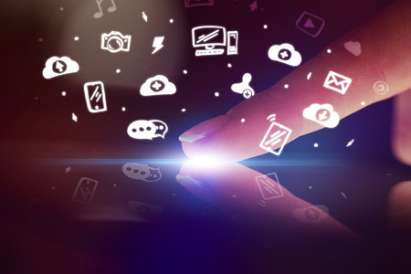 Finger touching tablet with white app icons aboveの写真素材